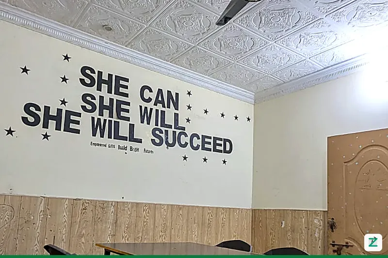 Training classroom wall at Zentyro Digital institute, Multan, with the message 'She Can, She Will, She Will Succeed — Empowered Girls Build Bright Futures'