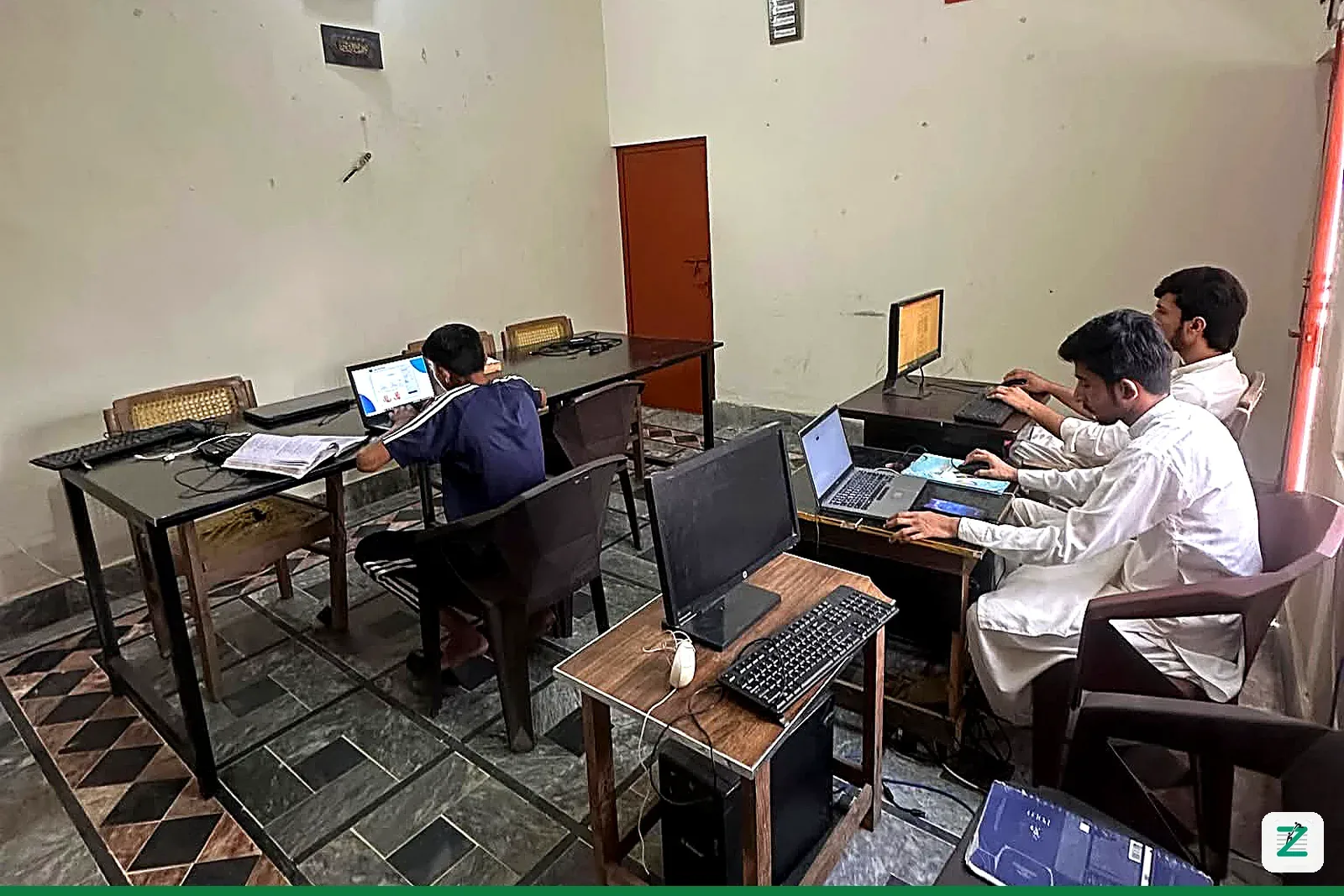 Students learning on laptops and computers in the Zentyro Digital computer lab classroom, Multan