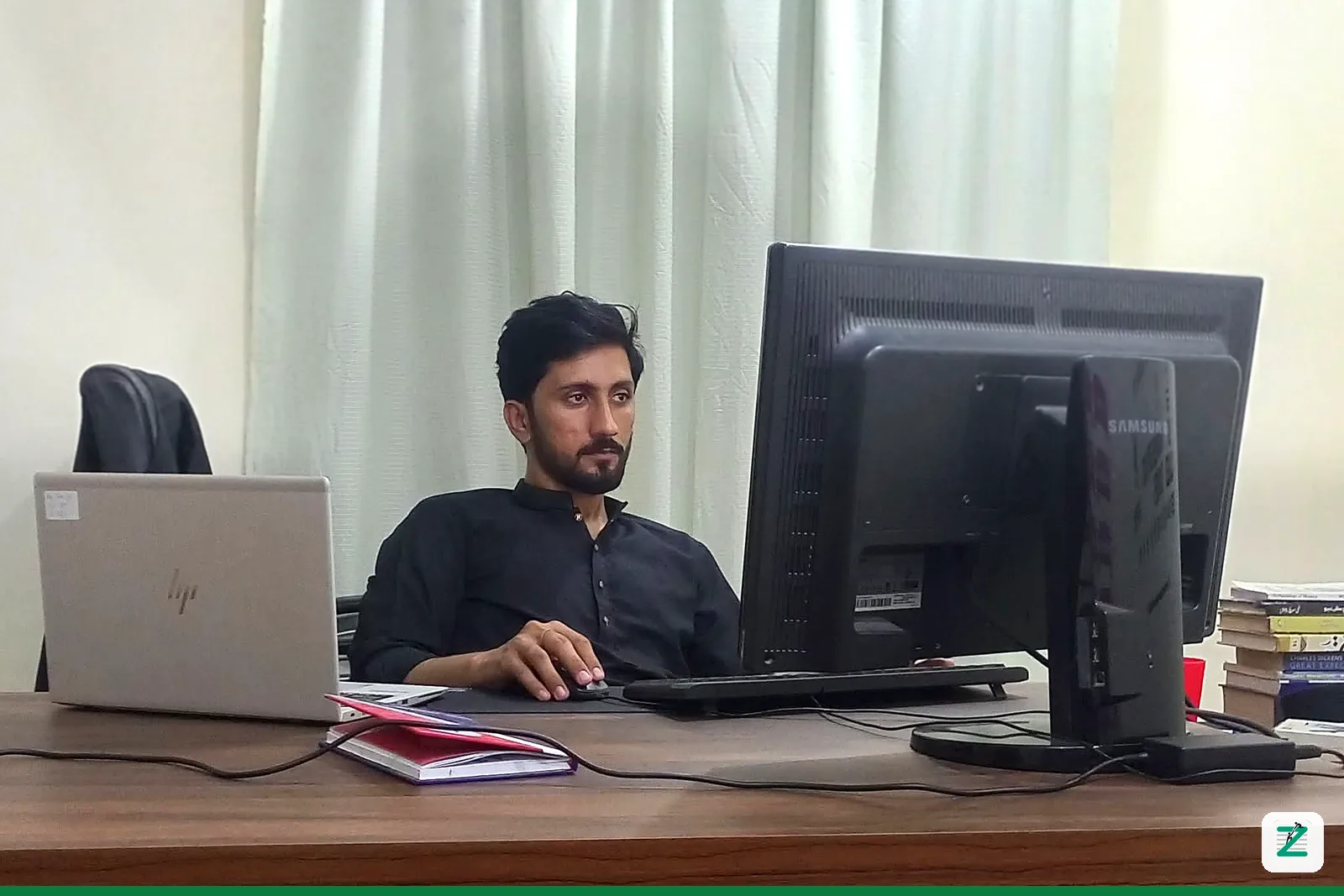 Trainer at his desk with a laptop and monitor at Zentyro Digital training institute, Multan