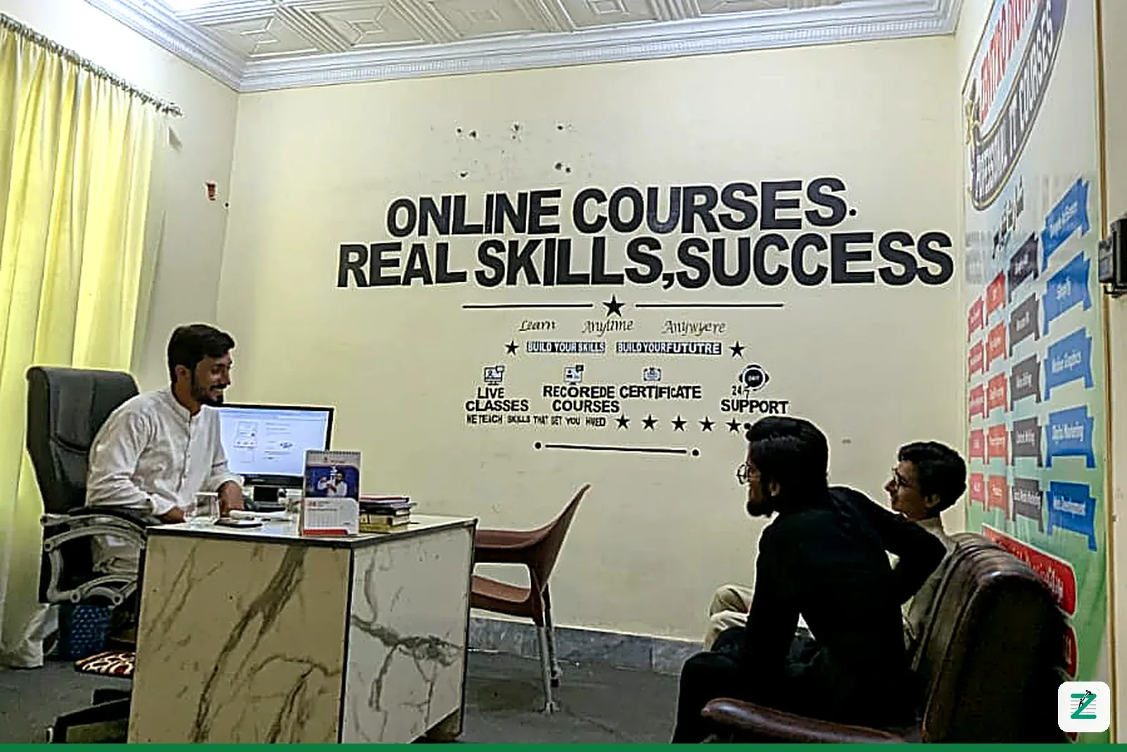 Visitors meeting a team member at the Zentyro Digital office in Multan, under the 'Online Courses, Real Skills, Success' wall sign